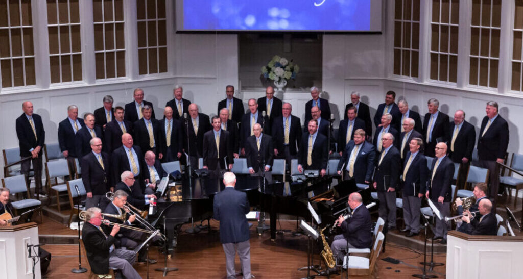 Alabama Singing Men stand on a stage during a performance.