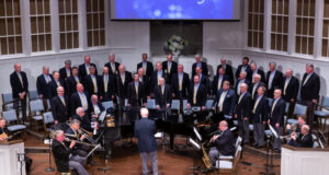 Alabama Singing Men stand on a stage during a performance.